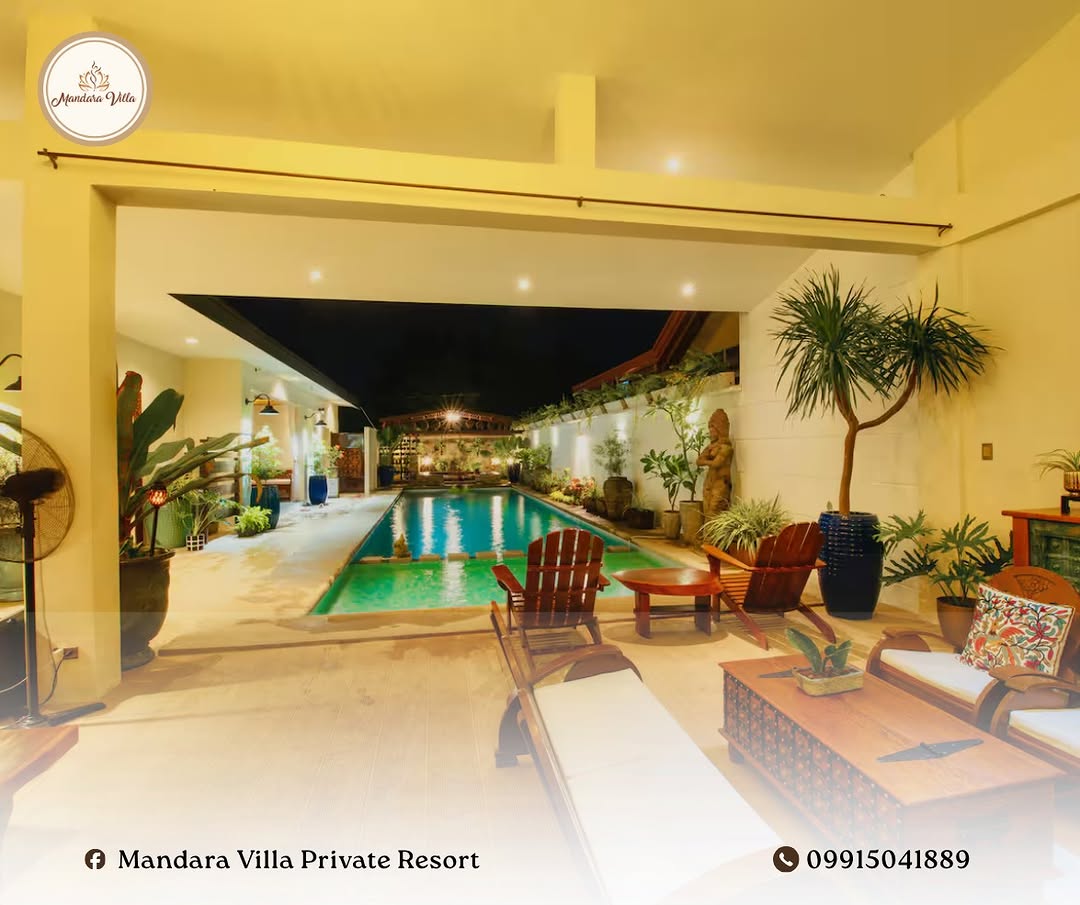 Natural hot spring pool at night — warm golden lighting, Adirondack chairs, Balinese statues and tropical plants